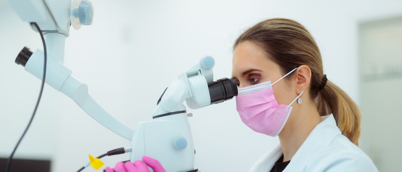 Woman looking through surgical microscope